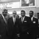 Athletes Jackie Robinson (left) and Floyd Patterson (third from left) are welcomed to riot-torn Birmingham, Ala., on May 13, 1963, by Wyatt Tee Walker (second from left) and a sign overhead. They came here to address an integration rally. (AP Images)